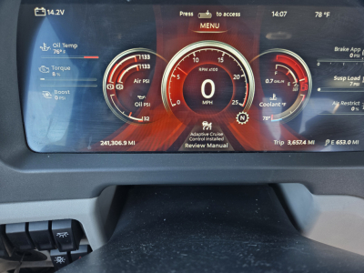 Peterbilt 579 instrument cluster display showing RPM gauge at 0, oil temp, oil pressure, boost, and trip metrics; left and right dials with various readings; VIN and stock number not visible on dashboard.