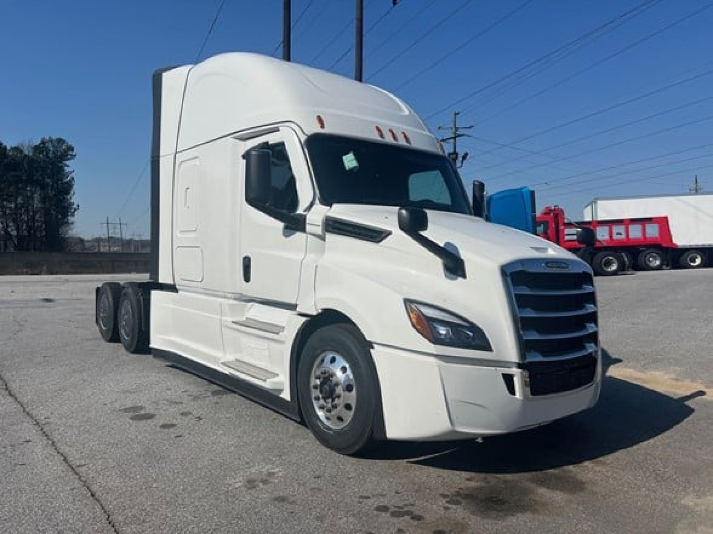 Frieghtliner Cascadia 126 conventional sleeper tractor in white, side view showing cab, dual rear axles, and front grille