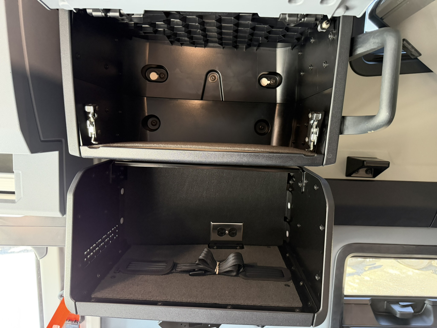 Cab interior showing storage compartments in a Mack PR64T76H truck cab with upper and lower compartments open.