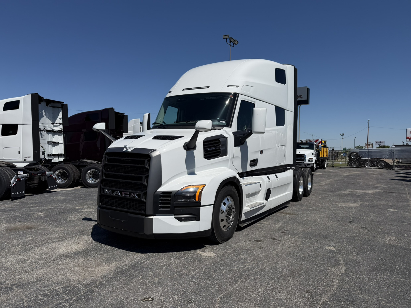 Truck: 2027 Mack PR64T76H conventional sleeper tractor shown in white with aerodynamic cab, front grille, and side mirrors.
