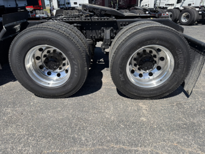 Quad rear truck wheels and chassis frame showing dual rear axles with chrome rims and tires.