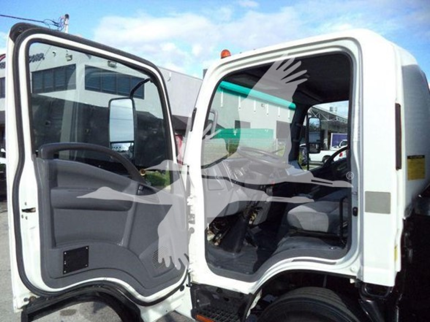 Isuzu NRR truck cab interior view with both doors open; dashboard and steering wheel visible.