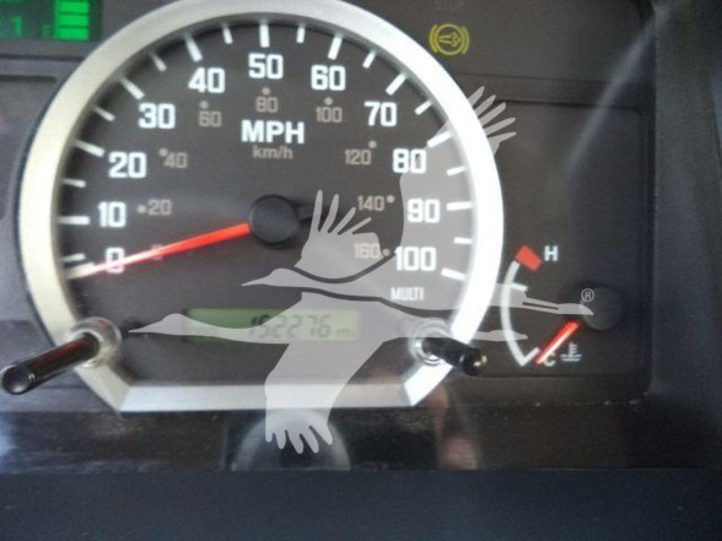 Isuzu NRR dashboard cluster showing speedometer and gauge needles with MPH and km/h markings.