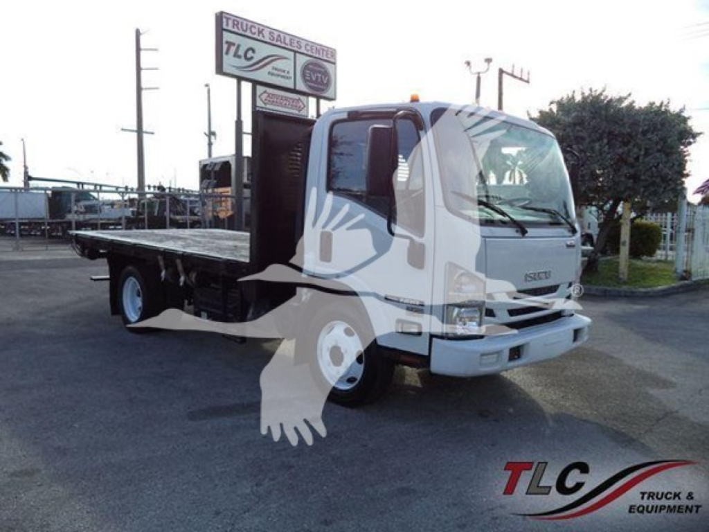 Isuzu NRR flatbed tow truck side/front view showing cab and flatbed with TLC Truck & Trailer Sales Center sign in background