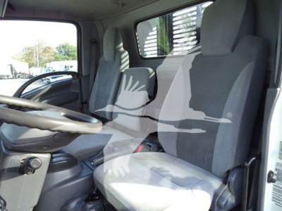 Isuzu NRR truck cab interior showing front seats and steering wheel with light gray upholstery.