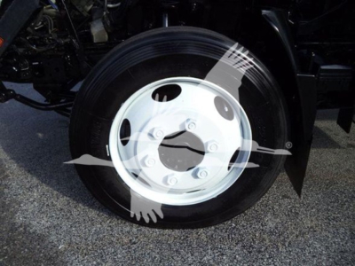Wheel and tire close-up on Isuzu NRR truck showing white steel wheel with lug nuts and black tire.