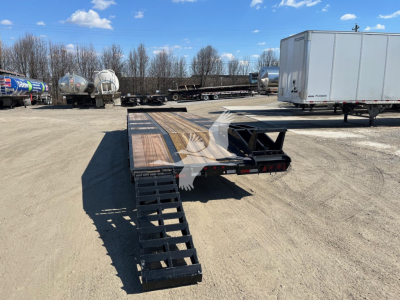 Trailer deck with fold-down ramps and ladder, 25XPL trailer in lot with white box trailer in background.