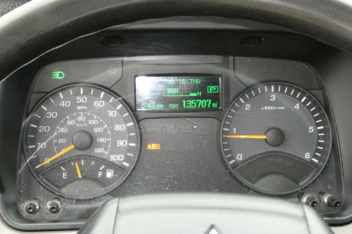 Dashboard view of a 2019 Mitsubishi Fuso Canter FE140 showing speedometer, tachometer, digital display with odometer 135,707 miles, ABS indicator, and other warning lights.
