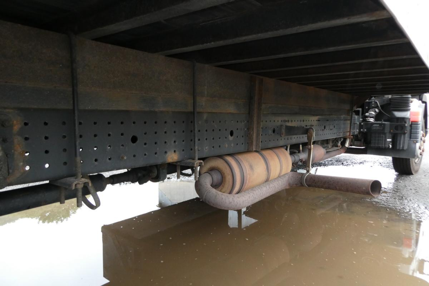 Underbody view of 2019 Mitsubishi Fuso Canter FE140 truck showing exhaust pipe and frame cross member.