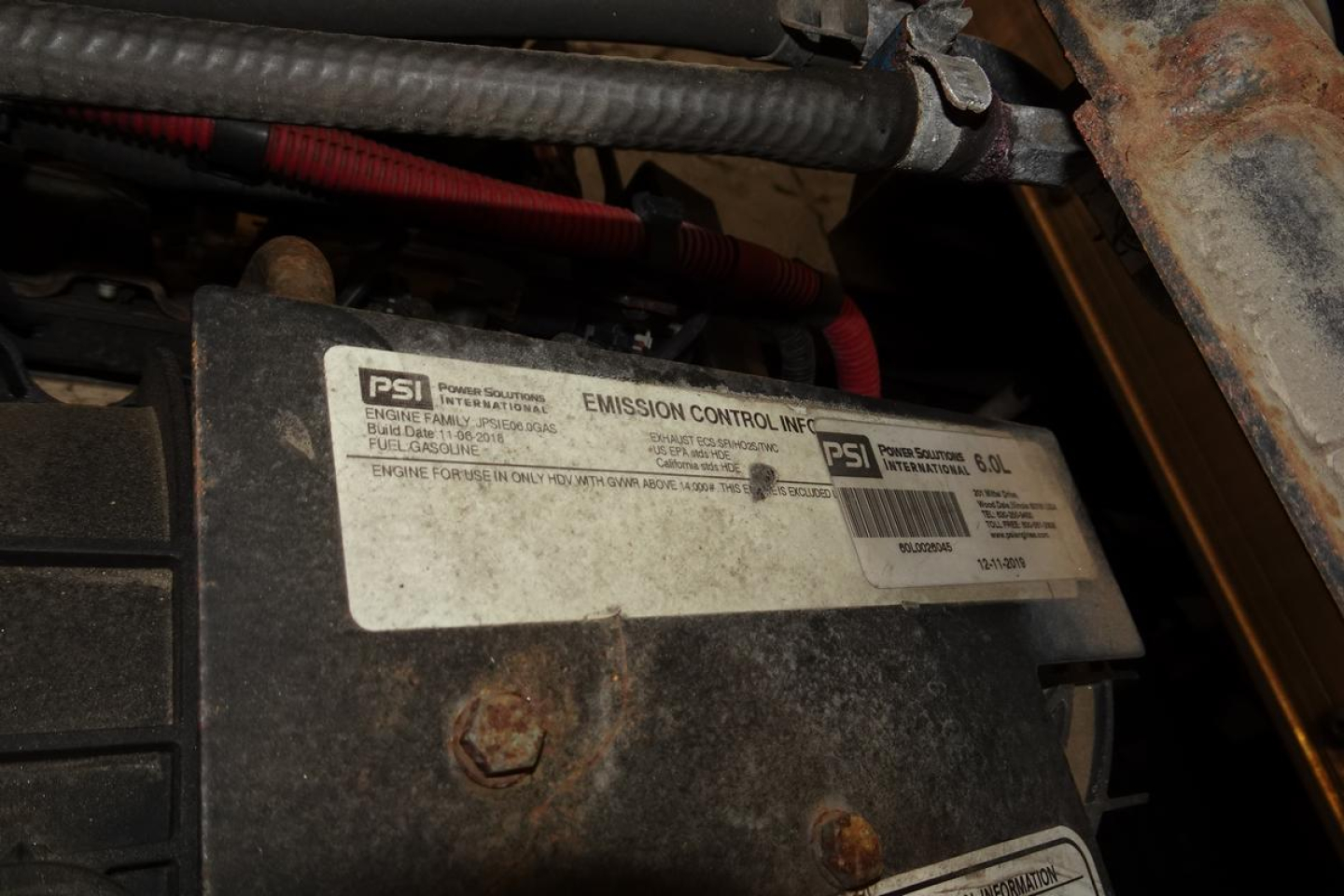 Mitsubishi Fuso Canter FE140 engine bay view showing emission control label and surrounding components.