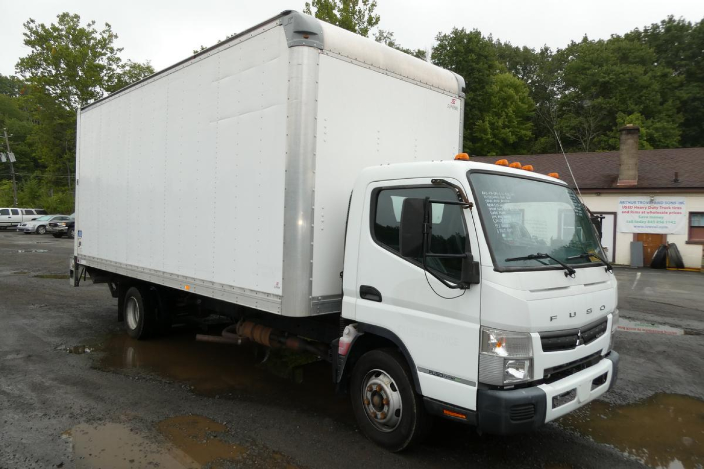 Box truck with white cargo box and cab, Mitsubishi Fuso Canter FE140, side view showing cab and box.