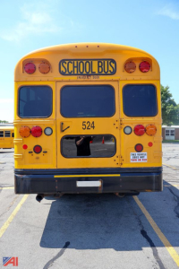 School bus rear view with yellow body, number 524, 'SCHOOL BUS' sign, dual rear lights, and warning decals.