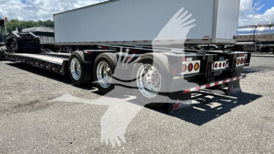 Flatbed trailer showing XL Specialized XL110HDGS with dual rear axle and hydraulic neck, lowboy design, chrome wheels, and registration stickers visible.