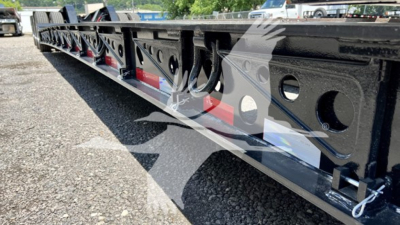 XL Specialized XL110HDGS lowboy trailer frame showing side holes, black painted steel with reflective red/white stickers and structural cross-members.
