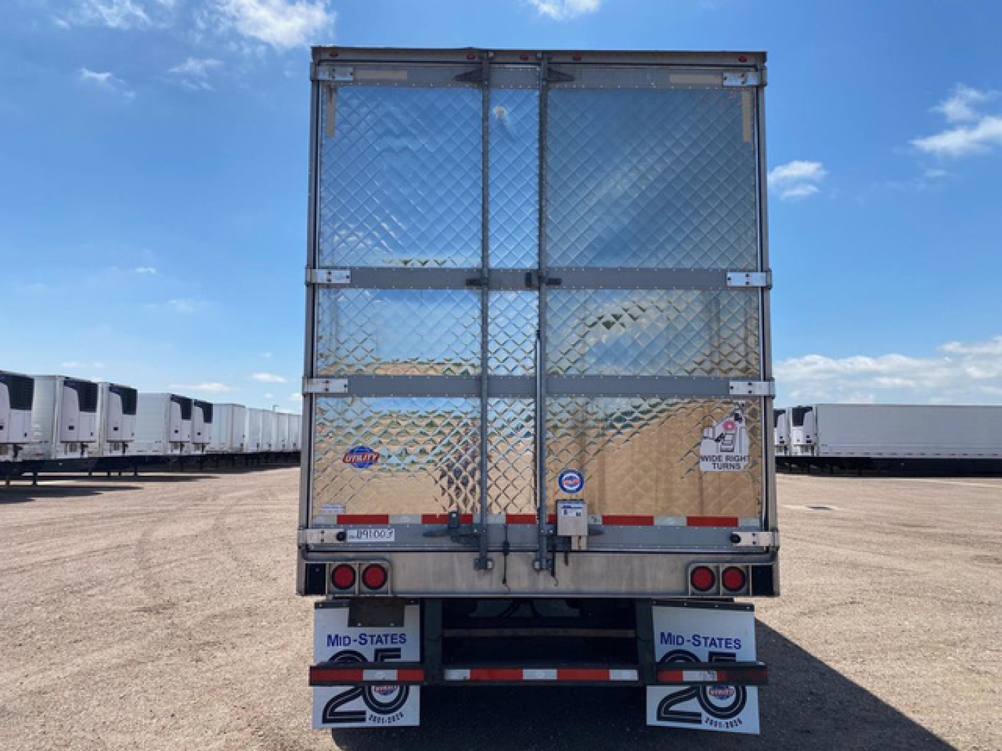 Refrigerated trailer back view with diamond plate doors and rear lights, U.S. trailer with mid-states mudflaps and reflective strips.