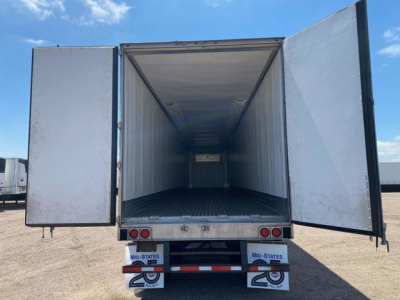 Refrigerated trailer cargo area open with rear doors swung out showing empty insulated box.