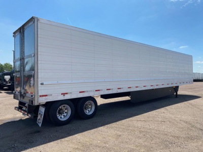 Utility reefer trailer showing white aluminum side panels and tandem rear axles with dual wheels.