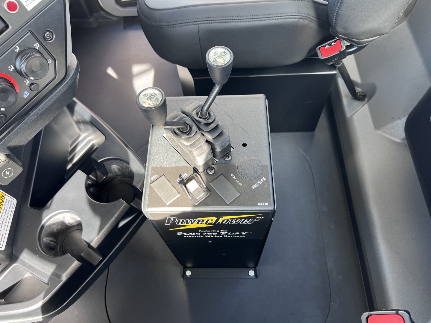 Rolloff truck cab interior showing control levers on PowerLifter unit and gear shifter area.