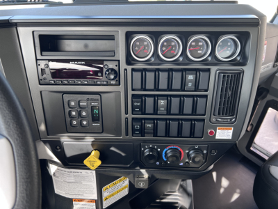 Mack GR64B truck dashboard showing multiple gauges, radio, climate controls, and switch panel. VIN 1M2GR4GCXTM053857 stock 70288 new roloff category.