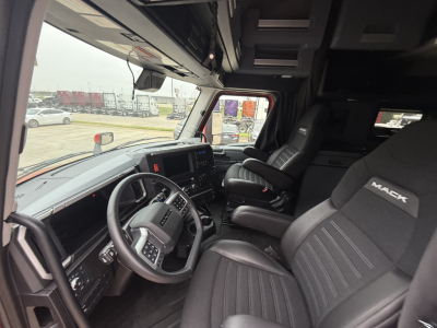 Mack PR64T76H truck interior showing steering wheel, dashboard, and front seats with Mack branding.