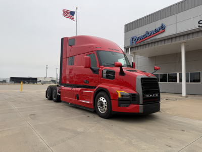 Heavy-duty red Mack tractor in-view showing aerodynamic sleeper cab and front grille with Mack emblem.