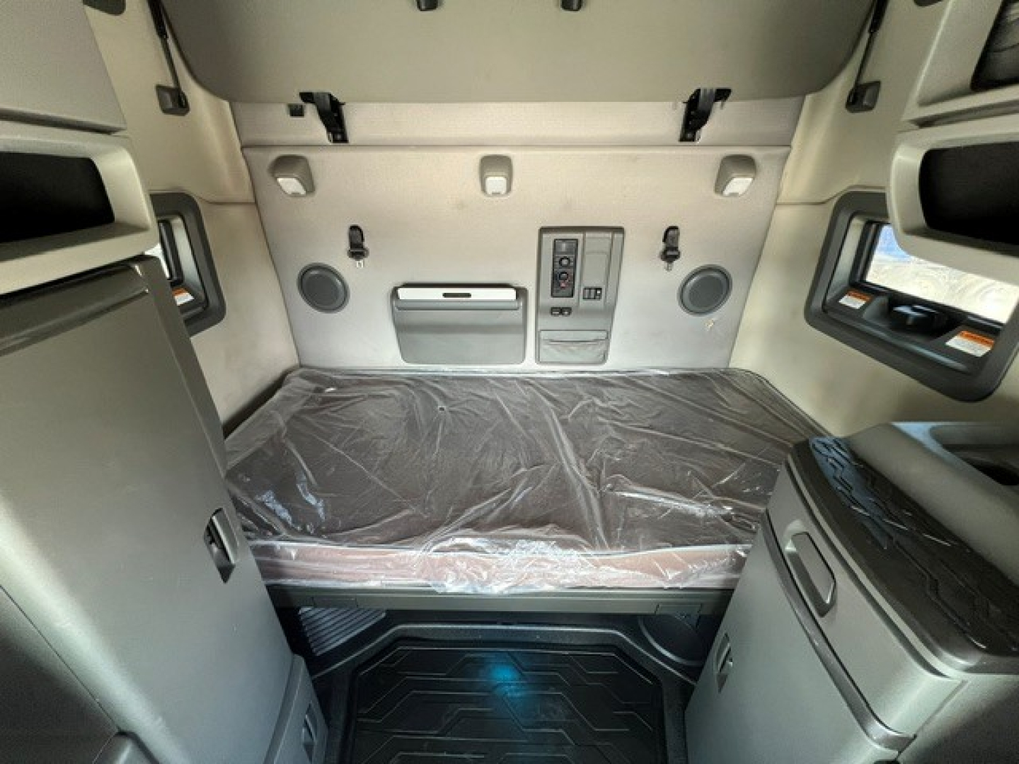 Interior sleeper cab of a 2020 Volvo VNL64T760 showing bed with plastic cover and storage compartments.