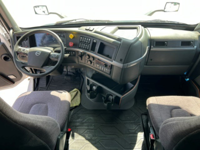 Volvo VNL64T760 truck cabin interior showing steering wheel, dashboard controls, and driver seat; gray cockpit with multiple gauges and center console.