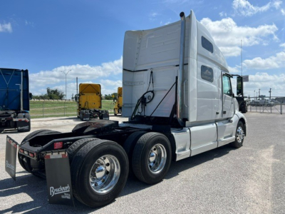 Volvo VNL64T760 sleeper tractor in a lot, side and rear view, with fifth wheel and dual rear axles visible.
