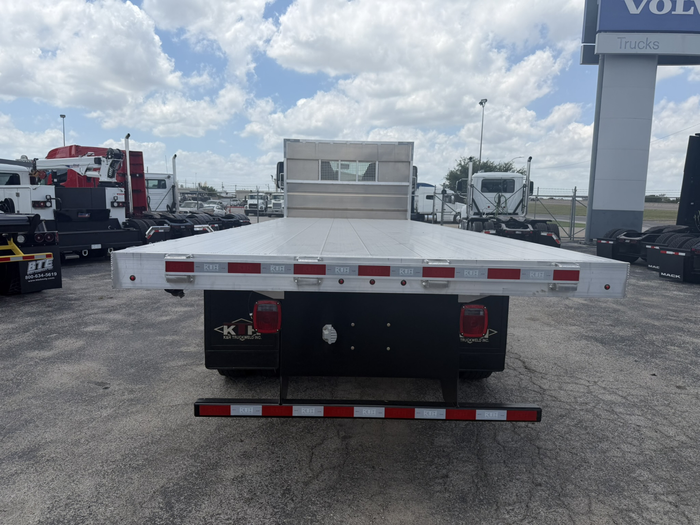 Flatbed truck bed rear view with aluminum deck and bumper lights on Mack MD6, VIN visible in listing, stock #68343.