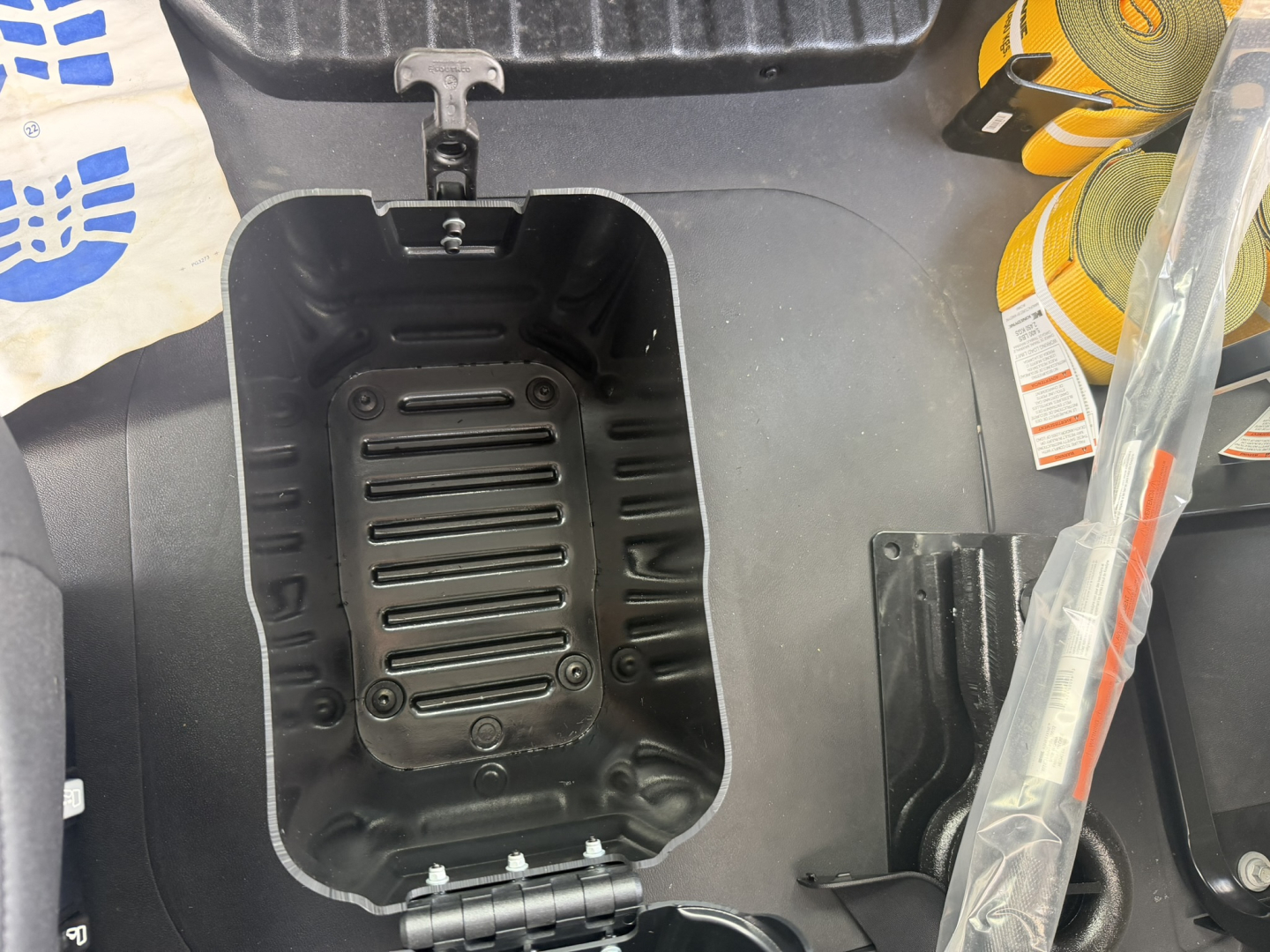 Mack MD6 engine bay showing open auxiliary fuel/tool tray with black plastic interior and surrounding components.