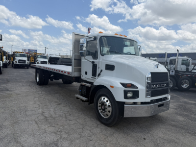 Mack MD6 flatbed truck in a dealership lot, white cab, aluminum flatbed, front view showing MACK grille and cab design.
