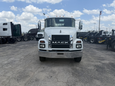 Front view of a white 2026 Mack MD6 flatbed truck showing grille, bumper, headlights, and Mack emblem.