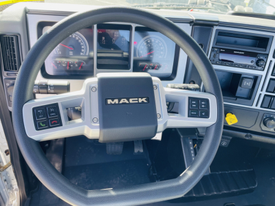 Mack MD6 truck interior steering wheel view showing dashboard gauges and control buttons