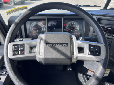 Steering wheel of a 2026 Mack GR64B with Mack badge, dashboard gauges visible in background.
