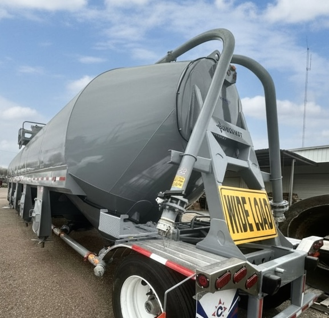 Conquest portable cement silo trailer with hopper and rear license plate area. Visible text includes 'WIDE LOAD' on rear plate area and 'Conquest' branding on the side and frame.