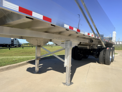 Trailer landing gear and underside of a Hicks FL2827 dump trailer showing stabilizer legs and wheel assembly.
