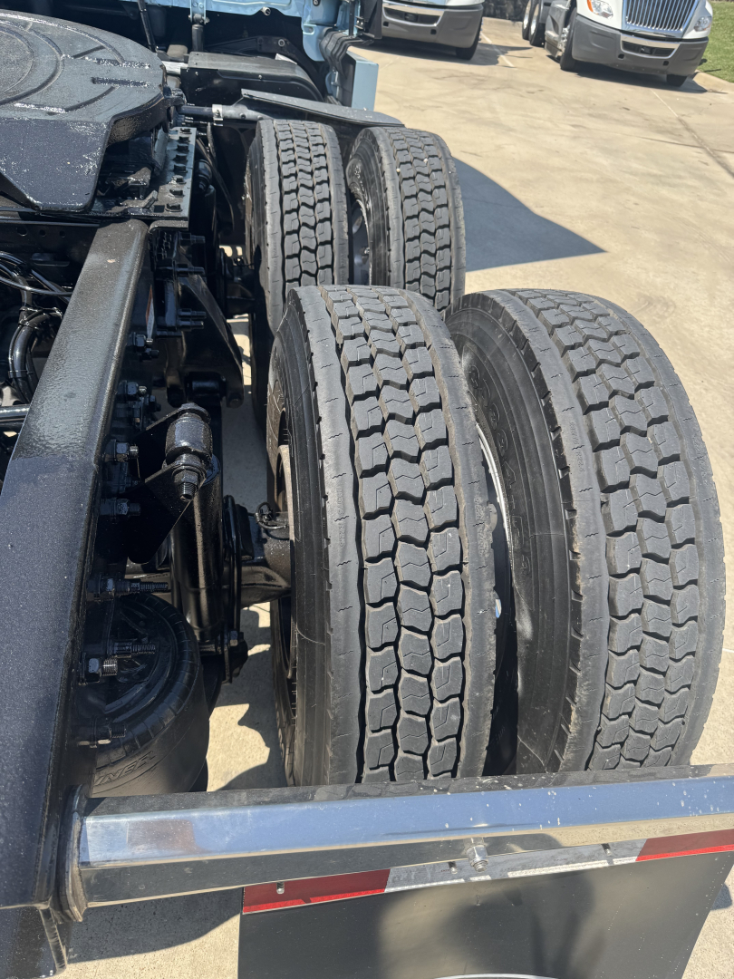 Rear view of a Freightliner Cascadia 126 tractor showing dual rear axles with treaded tires and chassis components.
