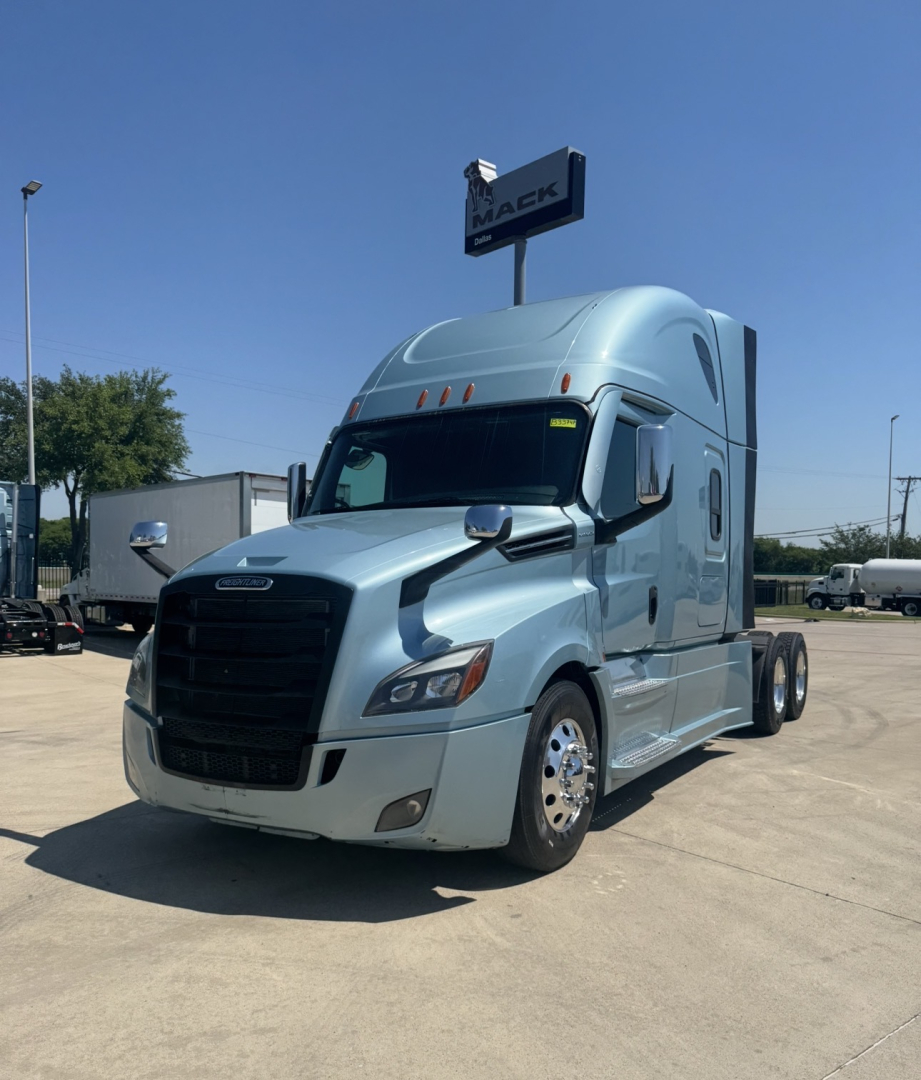 Truck cab in light blue 2023 Freightliner Cascadia 126 side view showing sleeper cab and front grille.