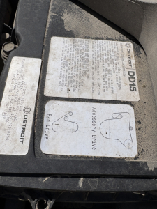 Label stickers on a Freightliner CASCADIA 126 engine bay; includes Detroit Diesel DDDL label and Fan Drive annotations with text blocks and diagrams.