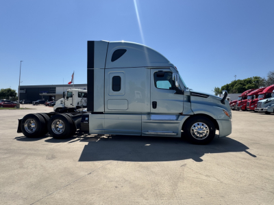 Freightliner Cascadia 126 sleeper cab truck, side view, with chrome wheels and light gray exterior.