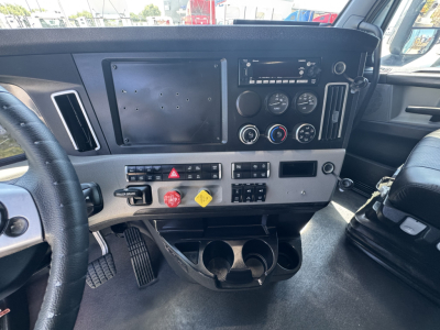 Dashboard panel of a Freightliner Cascadia 126 truck showing instrument cluster and controls, with blank square panel and various buttons.