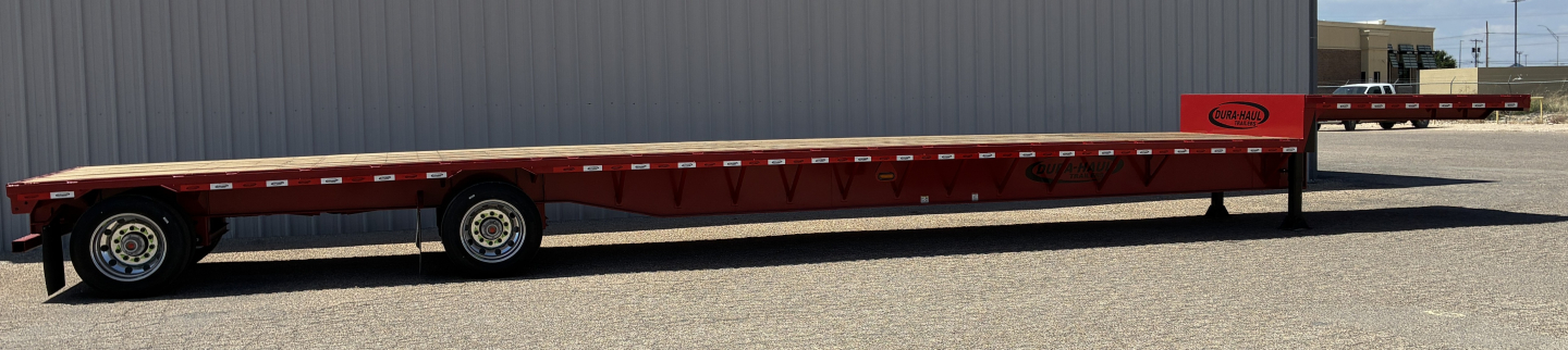 Long red 53' drop deck trailer with spread axles and black wheels, side decals and a gooseneck area, showing branding near the front and multiple support beams along the deck.