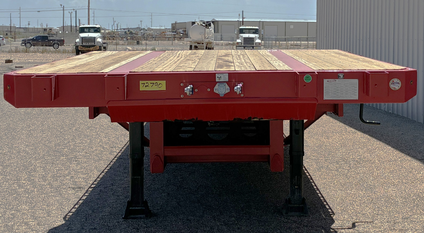 Red 2026 Dura Haul drop deck trailer with wooden deck, rear view showing support legs and wheel bays, flatbed style.