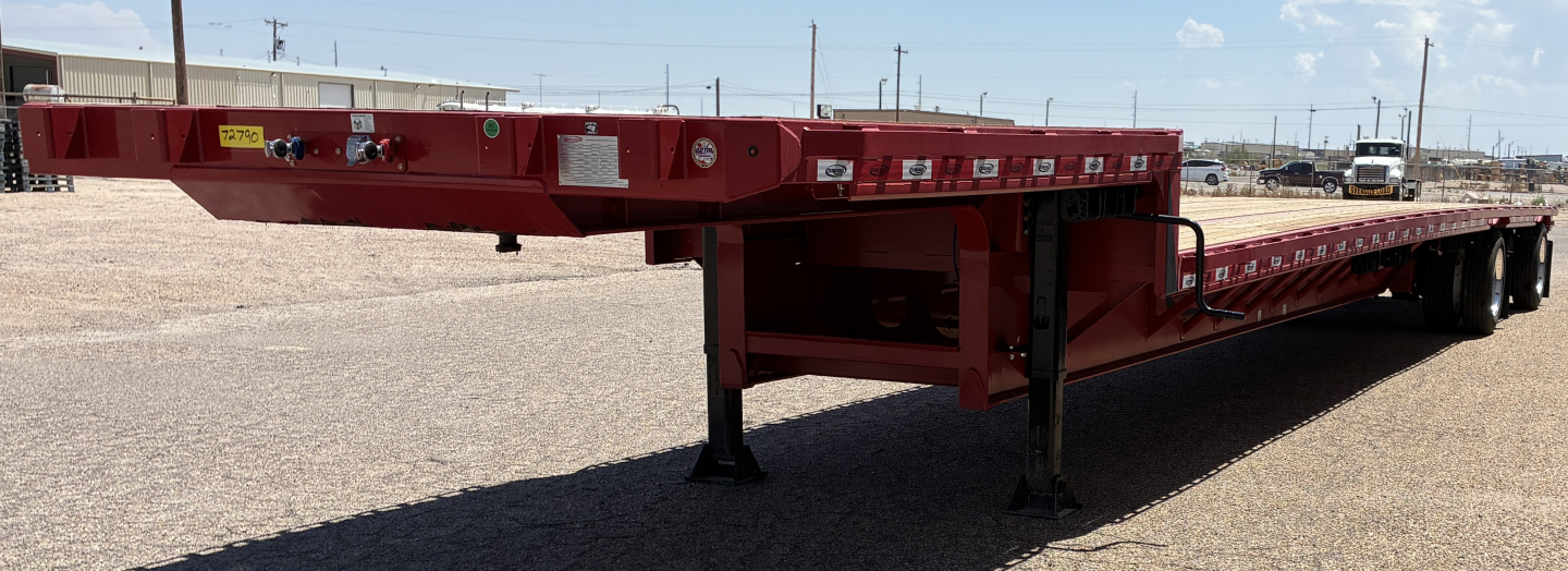 Trailer side profile showing a red 53' spread drop deck trailer with landing legs extended, multiple warning labels, and low-profile frame.