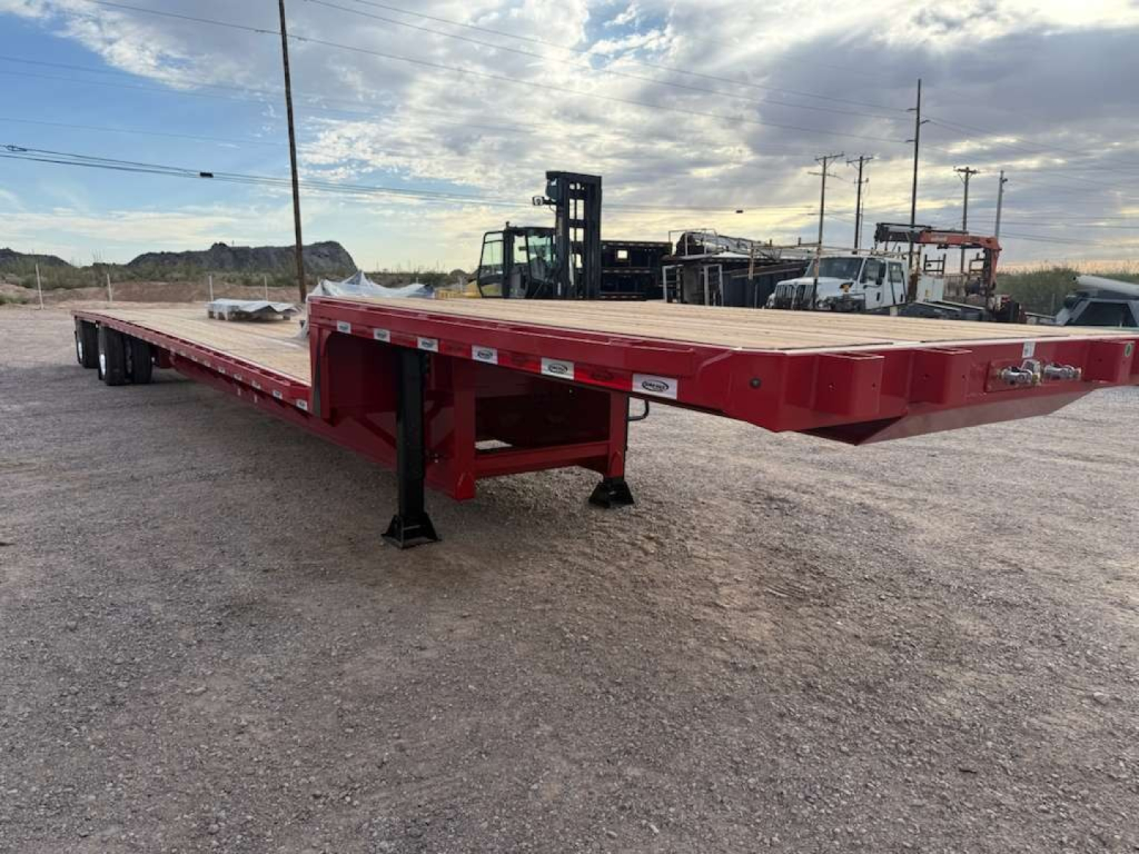 Trailer side view of a red 53' drop deck with black support legs and a low-profile frame.