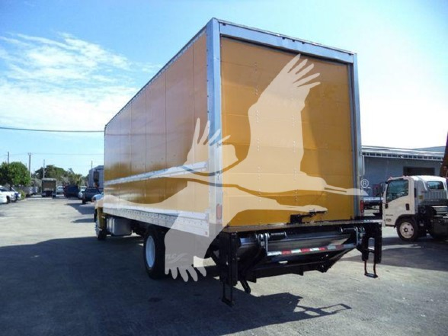 2019 Hino 268A box truck rear and side view showing long yellow cargo box and rear underride guard.