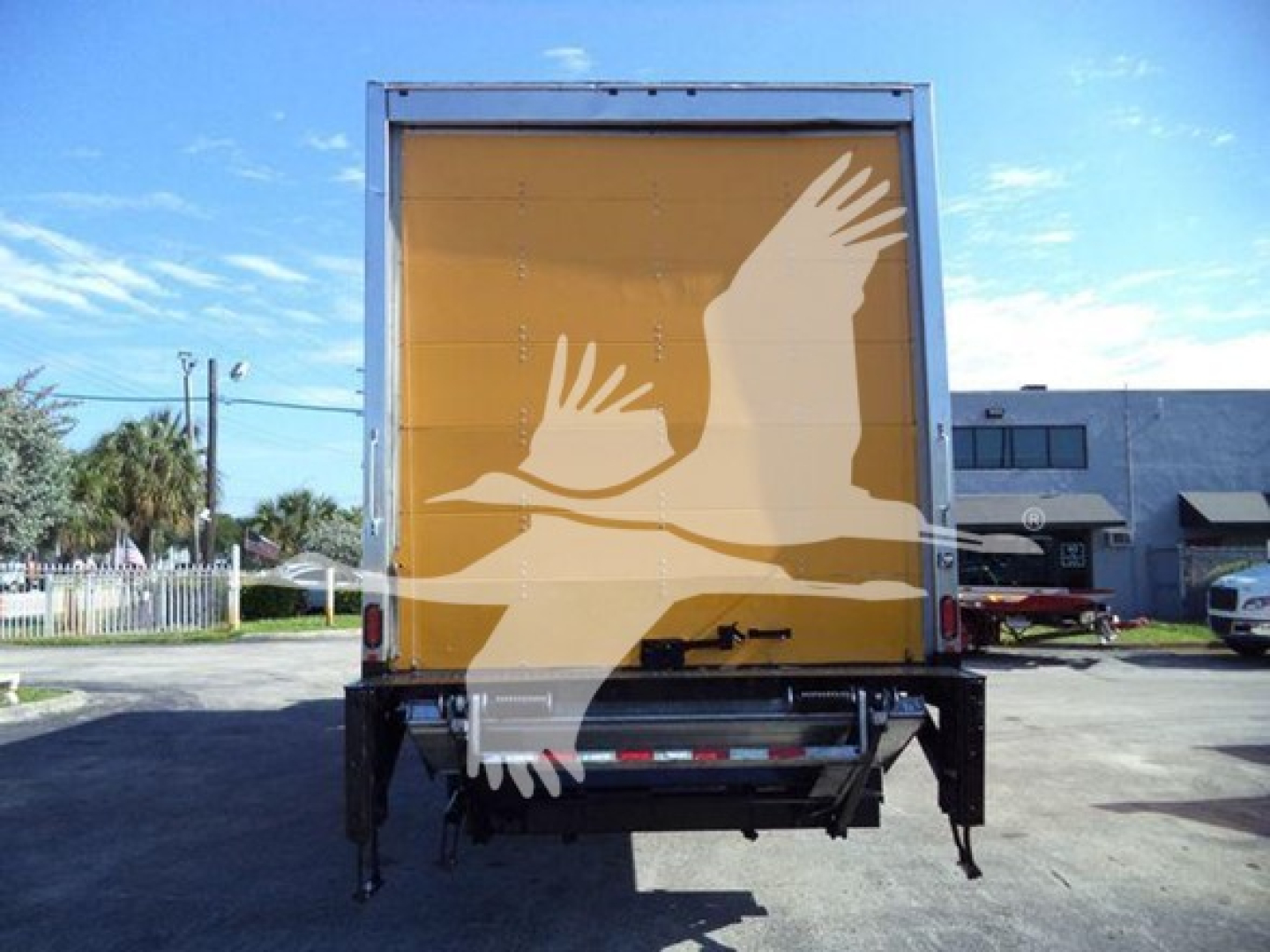 Truck box rear with yellow back and white bird graphic, rear undercarriage and tailgate visible