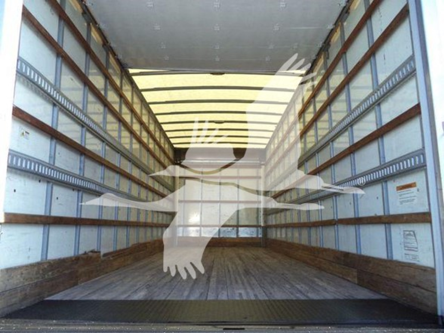 Truck interior showing empty cargo box with wooden floor and side rails, no visible equipment labels.