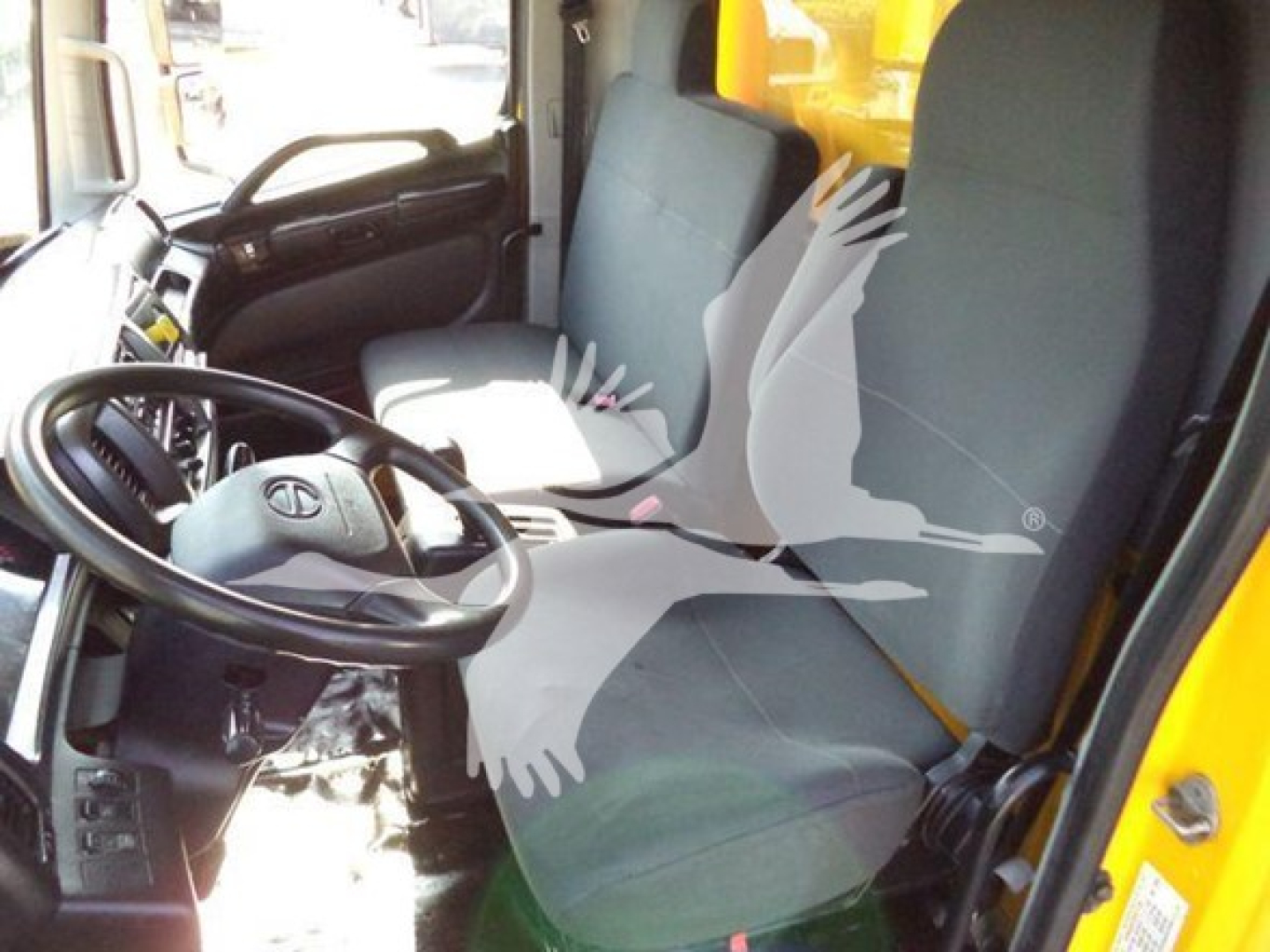 Interior of 2019 Hino 268A cab showing steering wheel and two front seats with gray upholstery.