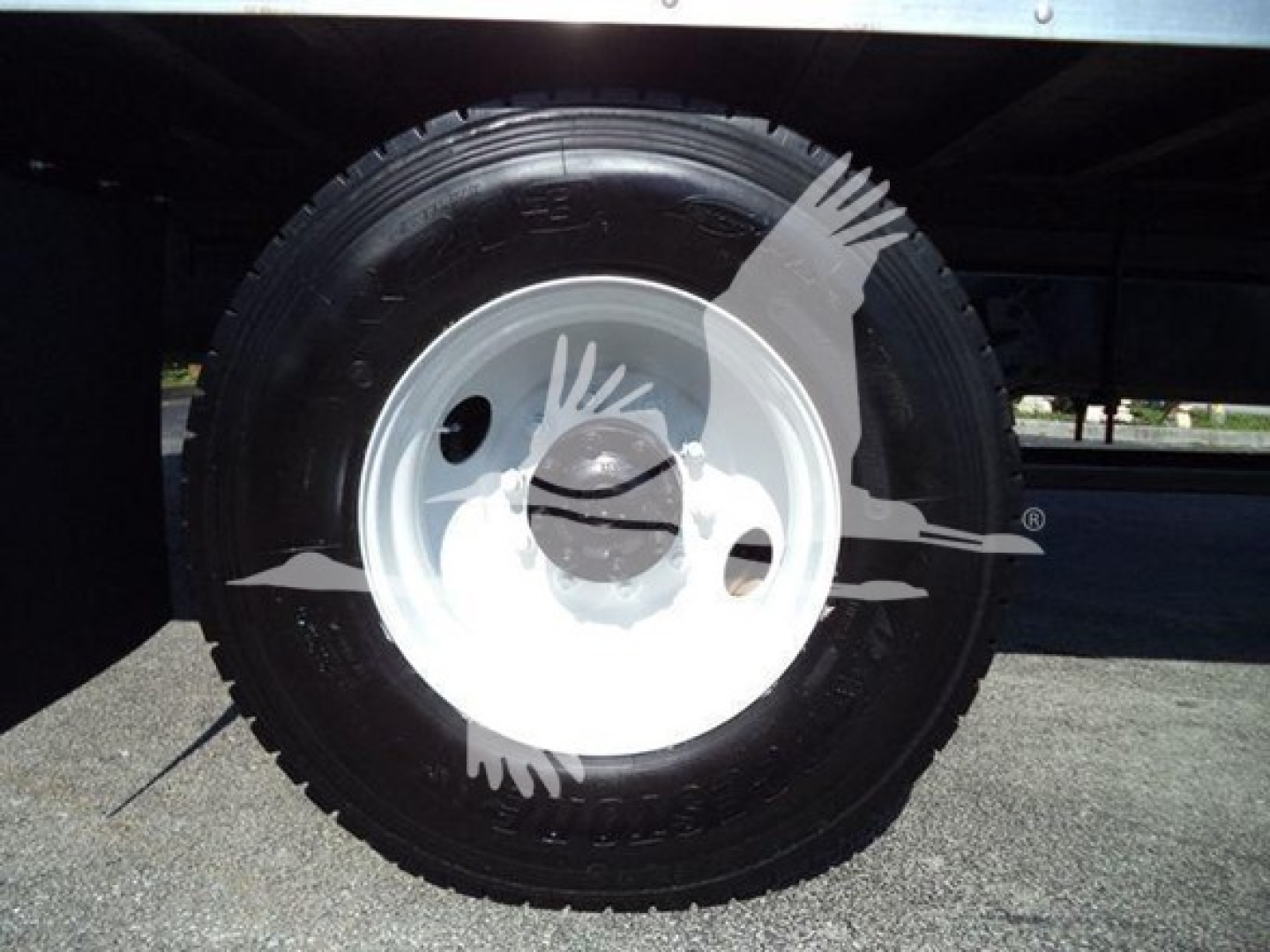 Truck wheel close-up showing tire and white steel rim; no visible text legible on tire.